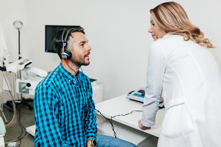 Patient with headphones on, looking at doctor