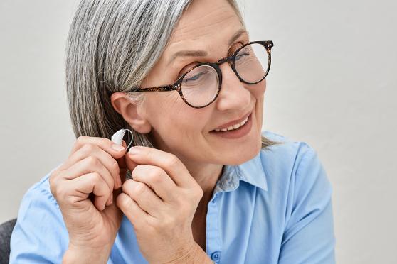 Woman putting on a hearing aid